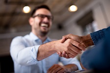 A man shaking hands in a professional setting.
