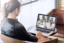 An employee with a computer in a Zoom-style meeting.